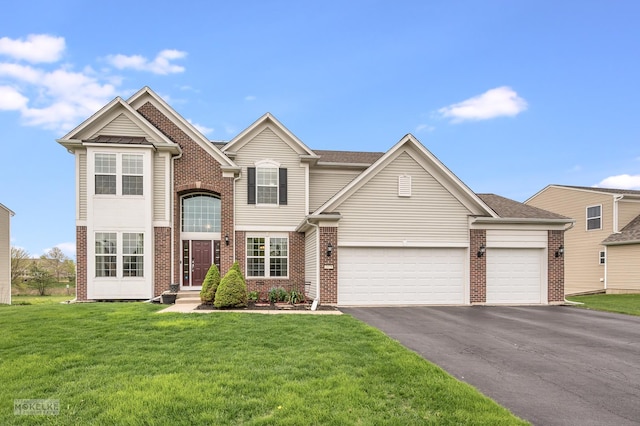 traditional-style house featuring brick siding, a garage, a front lawn, and aphalt driveway