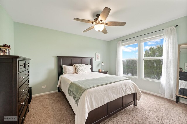 bedroom with baseboards, ceiling fan, and light carpet