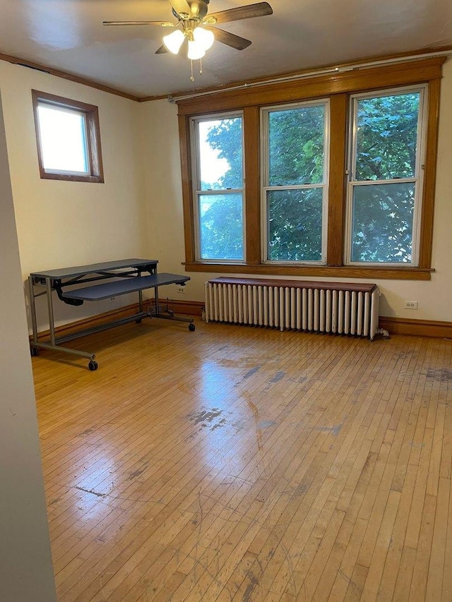 2500 Clarence Ave, Berwyn, IL 60402 - spare room with crown molding, radiator heating unit, ceiling fan, and hardwood / wood-style flooring