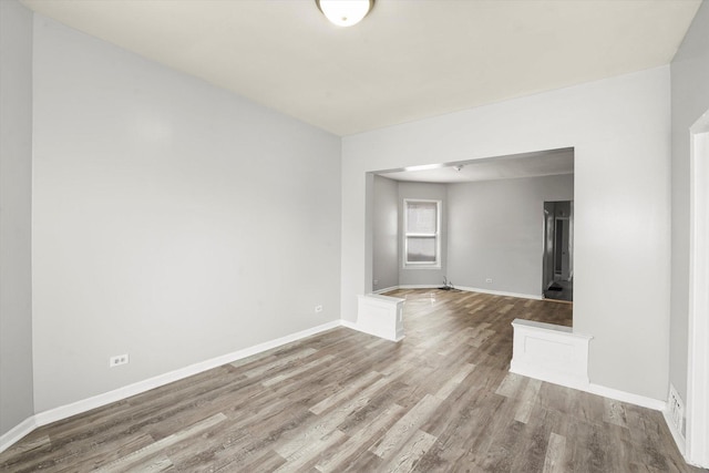 empty room featuring baseboards and wood finished floors