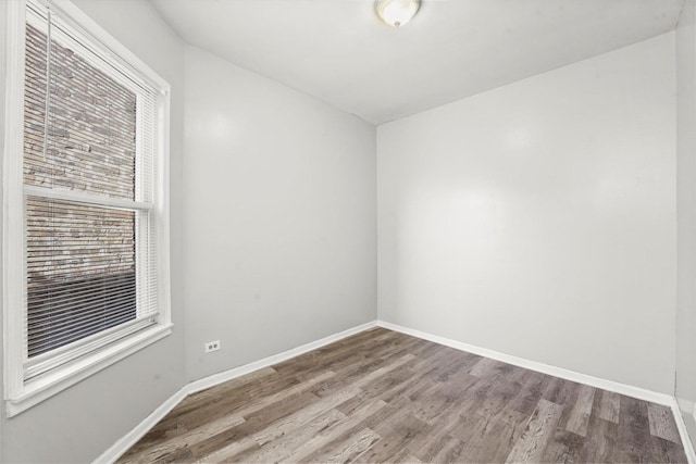 spare room featuring wood finished floors and baseboards