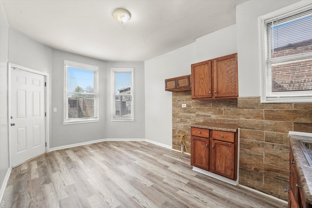 kitchen with light wood-style floors, baseboards, and brown cabinets