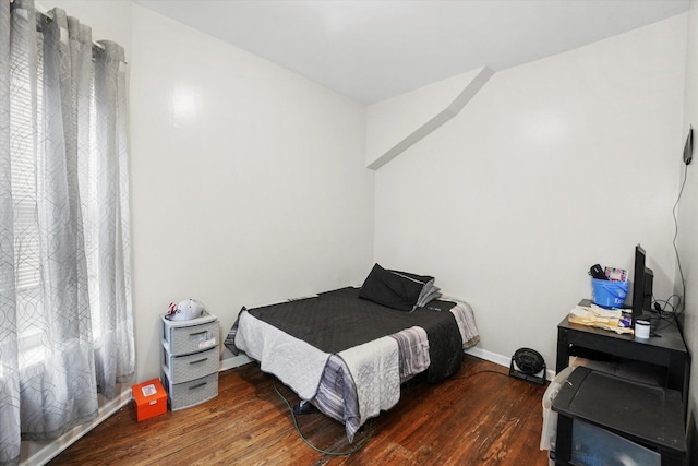 bedroom with wood finished floors and baseboards