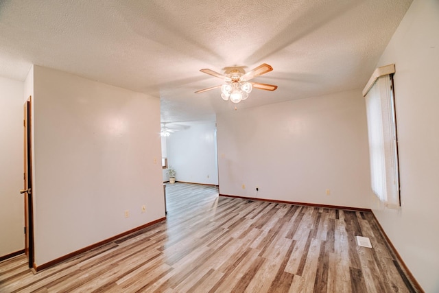 empty room with light wood finished floors, baseboards, a textured ceiling, and ceiling fan