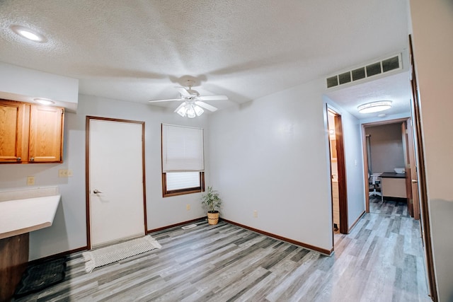 interior space with visible vents, light wood finished floors, and a textured ceiling