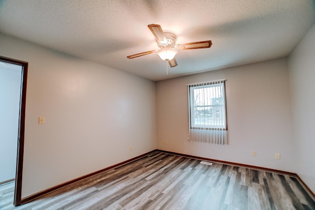 unfurnished room with a textured ceiling, baseboards, a ceiling fan, and wood finished floors