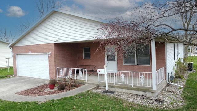 ranch-style house featuring covered porch, a garage, concrete driveway, and brick siding