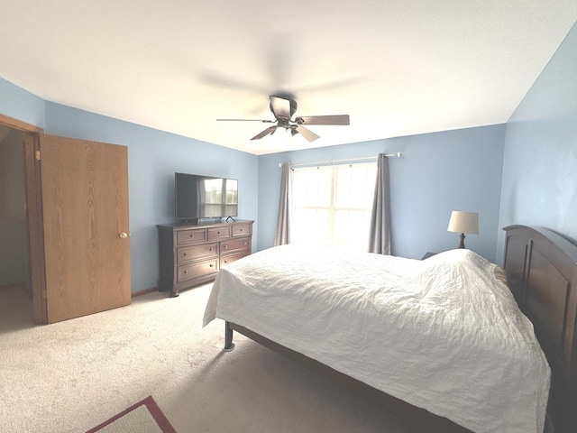 bedroom featuring light carpet and a ceiling fan