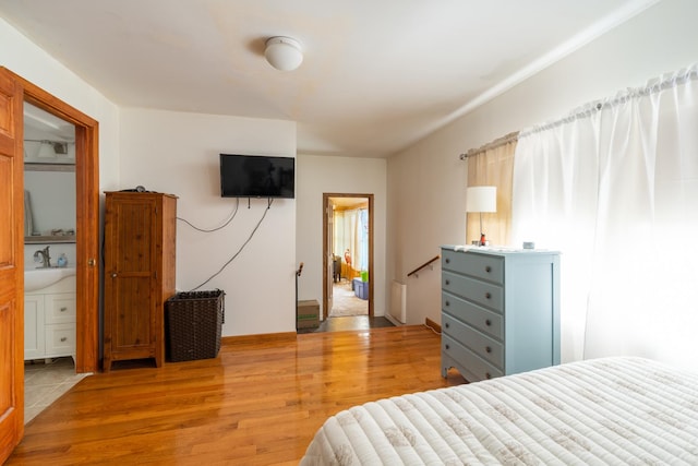bedroom featuring light wood-type flooring and a sink