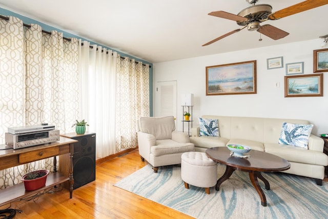living area with wood finished floors and a ceiling fan