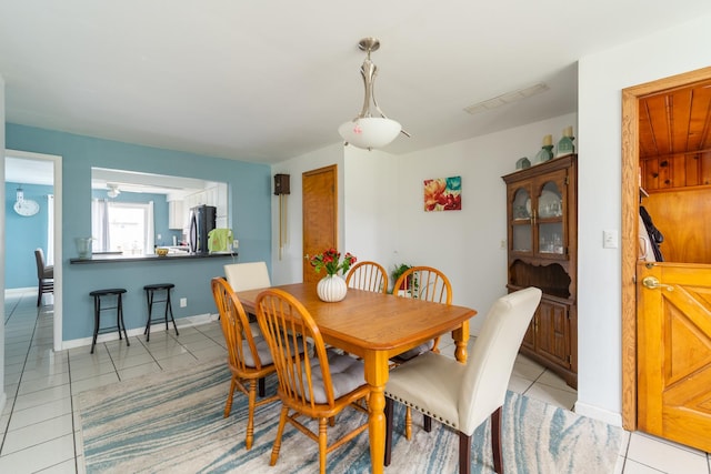 dining space featuring light tile patterned floors, baseboards, and visible vents