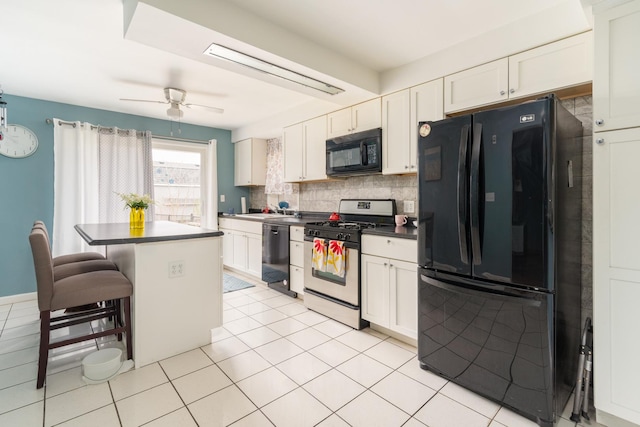 kitchen with a breakfast bar, white cabinetry, backsplash, dark countertops, and black appliances