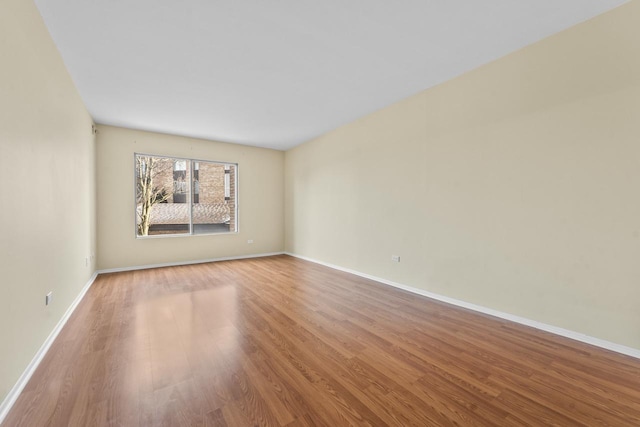 unfurnished room featuring baseboards and wood finished floors