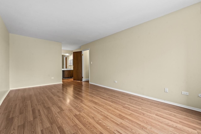 empty room with light wood-style flooring and baseboards