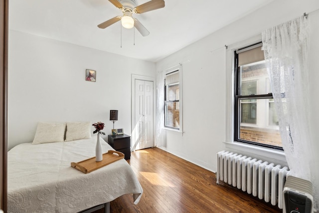 3418 N Oak Park Ave, Chicago, IL 60634 - bedroom featuring a closet, baseboards, ceiling fan, wood finished floors, and radiator heating unit