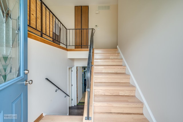 stairway featuring visible vents and wood finished floors