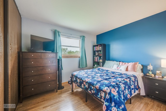 bedroom with baseboards and wood finished floors