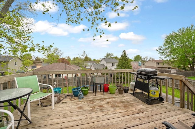 deck with a fenced backyard, grilling area, and a residential view