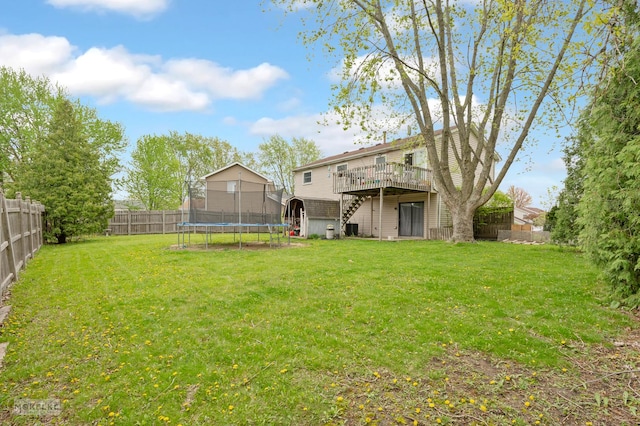 view of yard featuring stairs, a fenced backyard, a trampoline, and a wooden deck