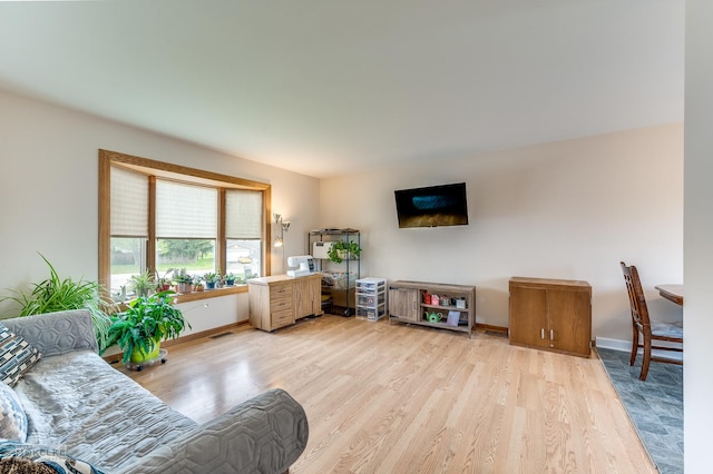 living room featuring baseboards, light wood-type flooring, and visible vents