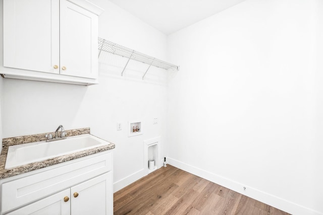 laundry room with baseboards, a sink, light wood-type flooring, cabinet space, and hookup for a washing machine