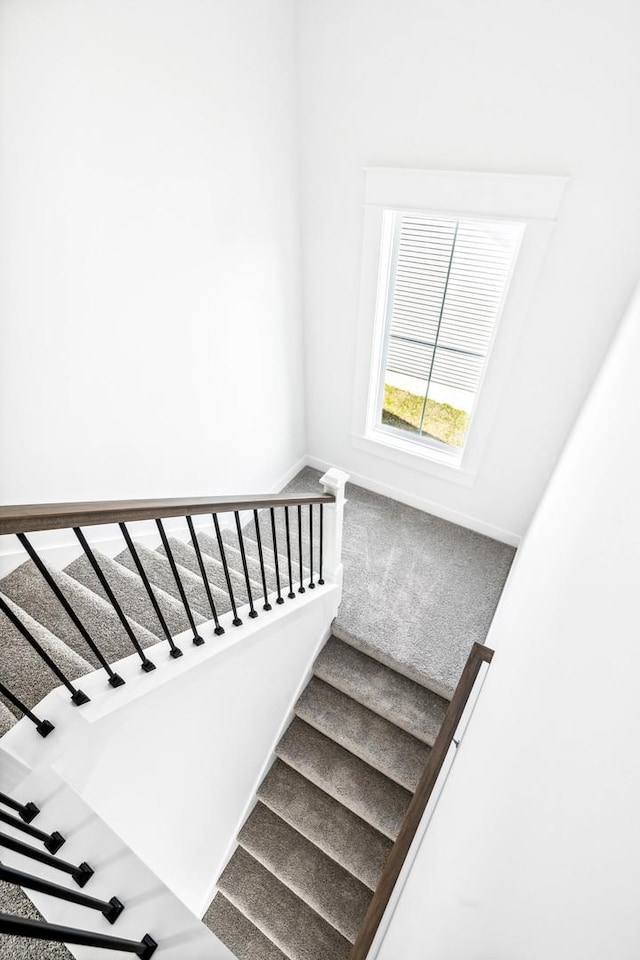 stairs featuring carpet flooring and baseboards