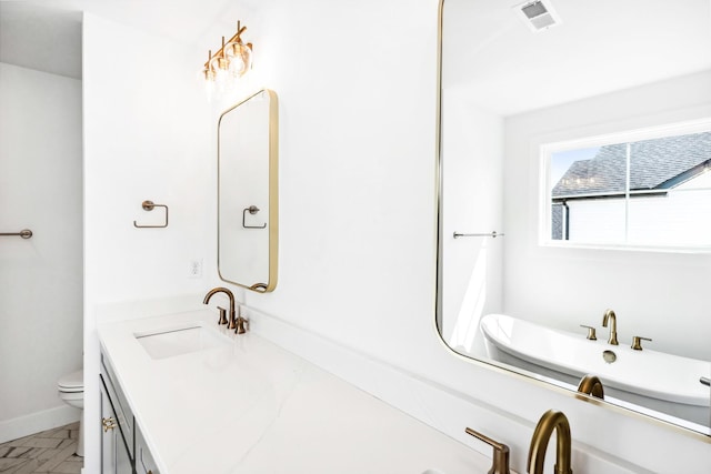 bathroom featuring vanity, visible vents, baseboards, and toilet