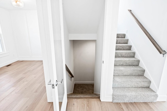 staircase featuring wood finished floors and visible vents