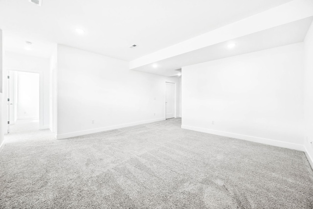 carpeted empty room with visible vents, baseboards, and recessed lighting