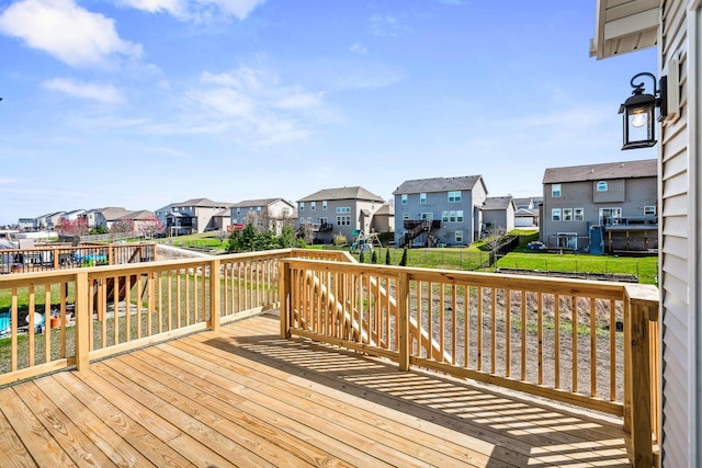 wooden terrace featuring a residential view and a lawn