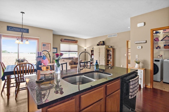411 Anjali Ct, Sycamore, IL 60178 - kitchen with a sink, dishwasher, brown cabinetry, a chandelier, and a kitchen island with sink