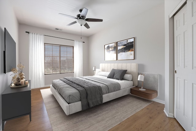 bedroom with visible vents, baseboards, a ceiling fan, and light wood-style flooring