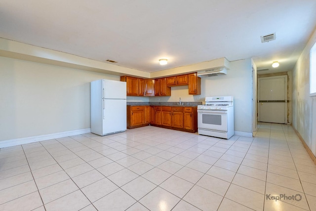 kitchen featuring visible vents, a sink, white appliances, under cabinet range hood, and brown cabinets