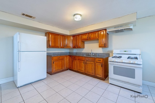 kitchen with brown cabinets, visible vents, and white appliances