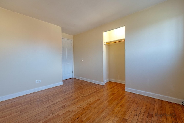 unfurnished bedroom featuring a closet, light wood finished floors, and baseboards