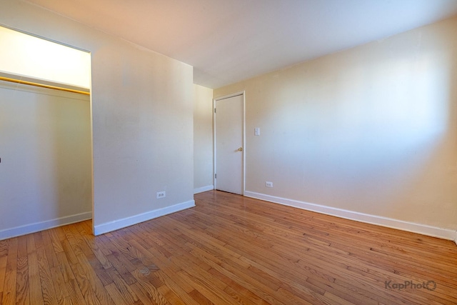 unfurnished bedroom featuring a closet, baseboards, and wood finished floors