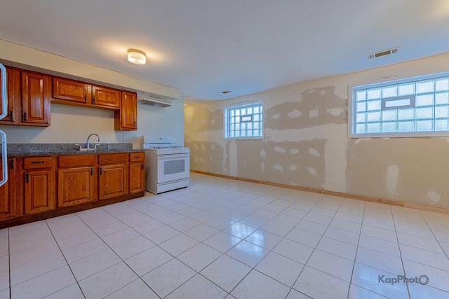 kitchen with brown cabinets, visible vents, baseboards, and gas range gas stove