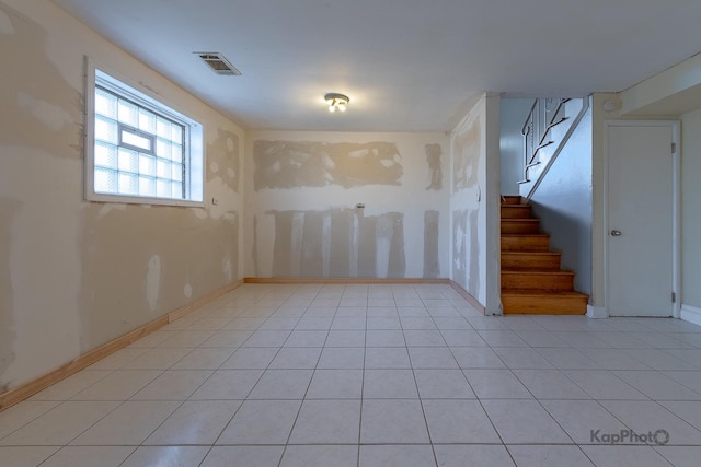 interior space with visible vents, baseboards, light tile patterned floors, and stairs