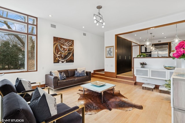 living area featuring recessed lighting, light wood-style flooring, and visible vents