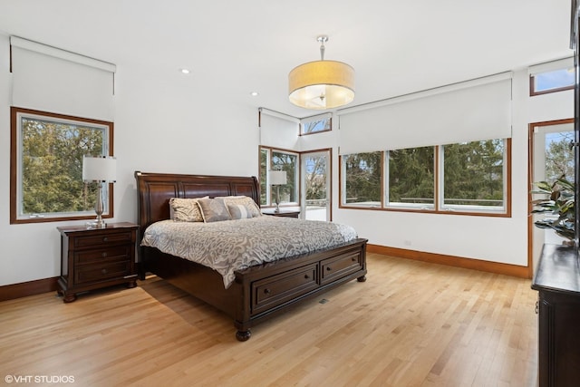 bedroom with light wood-type flooring, baseboards, and recessed lighting