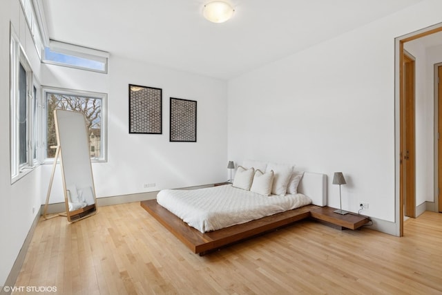 bedroom featuring light wood-style flooring and baseboards