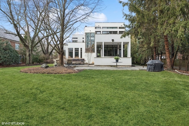 rear view of property featuring stucco siding and a lawn