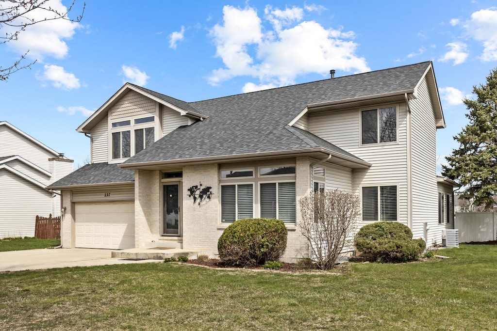 237 Whitetail Xing, Oswego, IL 60543 - traditional-style home with driveway, cooling unit, a shingled roof, a front yard, and a garage