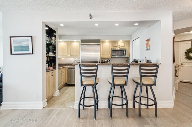 195 N Harbor Dr Unit 2602, Chicago, IL 60601 - kitchen with a textured ceiling, light wood-style floors, appliances with stainless steel finishes, and a kitchen bar