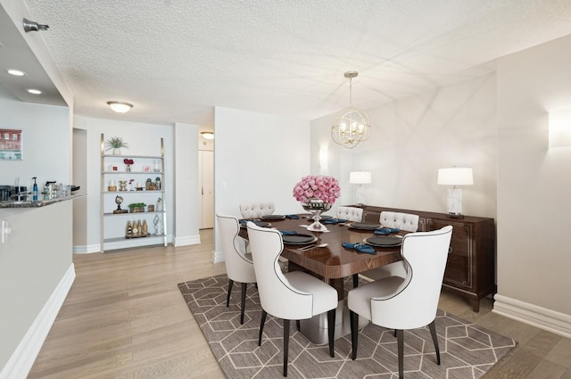 195 N Harbor Dr Unit 2602, Chicago, IL 60601 - dining space featuring a textured ceiling, baseboards, a notable chandelier, and wood finished floors