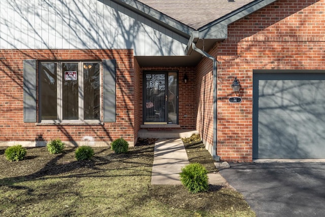 property entrance featuring a garage, brick siding, and a shingled roof