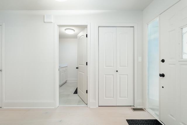 entrance foyer featuring visible vents, light wood-style flooring, and baseboards