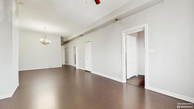 empty room featuring visible vents, baseboards, dark wood-style floors, and ceiling fan with notable chandelier