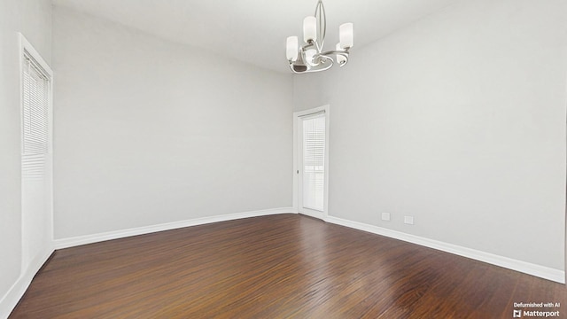 unfurnished room with dark wood-type flooring, baseboards, and a notable chandelier