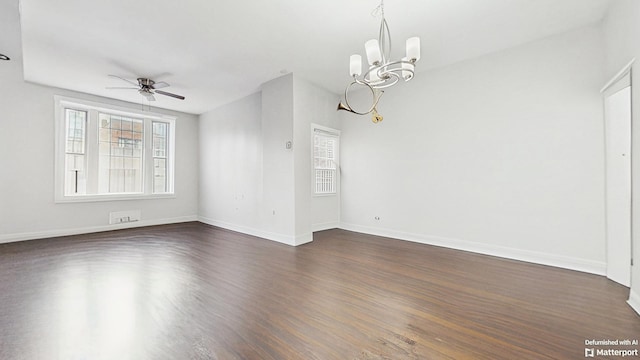 spare room featuring ceiling fan with notable chandelier, baseboards, and dark wood-style floors